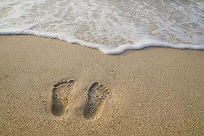 High angle view of footprints on sand at beach