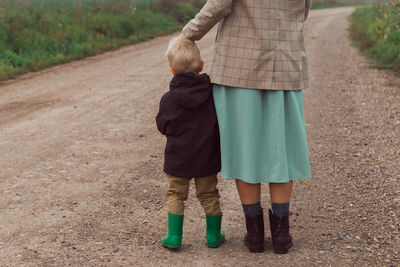 Family walking in corn field at autumn, kid hug parent