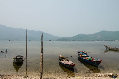 Boats moored in sea against clear sky