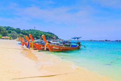 Boat moored on beach against sky