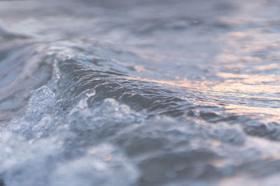 Close-up of wave in sea during sunset
