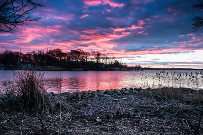 Scenic view of lake against sky at sunset