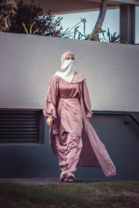 Rear view of woman standing against wall