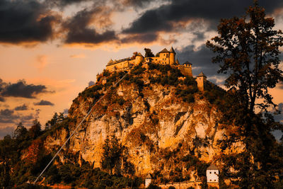 Low angle view of castle on hill against sky during sunset