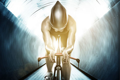 Woman cycling through tunnel