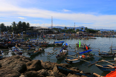 Boats moored at harbor against sky