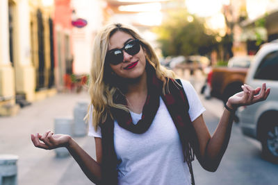 Beautiful woman in sunglasses standing on road