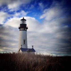 Low angle view of lighthouse on field against sky