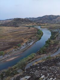 Scenic view of landscape and river against sky