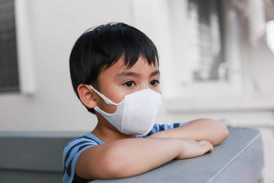 Side view of young woman wearing protective mask