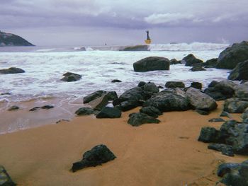 Rocks on beach against sky