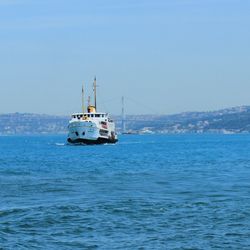 Sailboat sailing on sea against clear sky