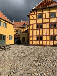 Houses by street in town against sky