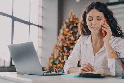 Smiling businesswoman talking on phone at office