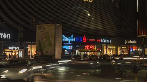 Illuminated sign on street in city at night