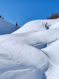 Scenic view of snow covered mountain against blue sky