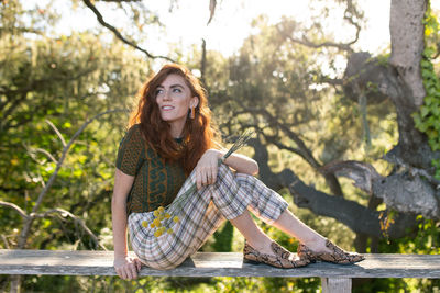 Portrait of smiling young woman sitting outdoors