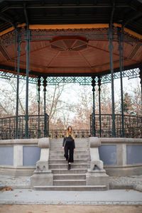 Rear view of woman standing on staircase in building