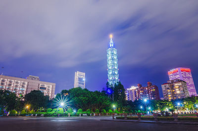 Illuminated modern buildings against sky at night