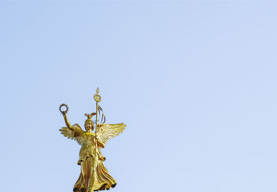 Low angle view of angel statue against clear sky