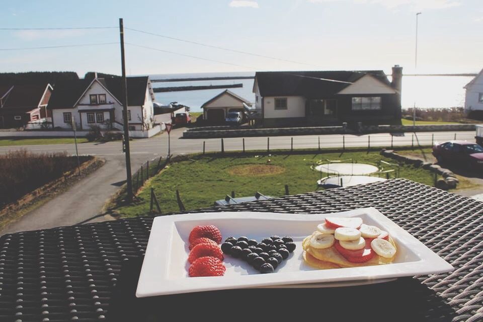 food and drink, building exterior, architecture, built structure, food, freshness, table, sky, house, day, healthy eating, residential structure, no people, window, outdoors, sunlight, residential building, potted plant, plate, fruit