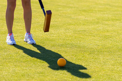 Female croquet player hitting the ball with mallet