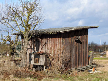 Abandoned barn on field against sky