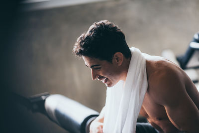 Side view of young man looking at camera