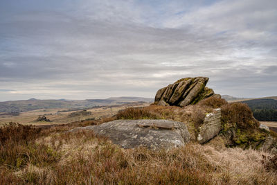 Rock formation on field against sky