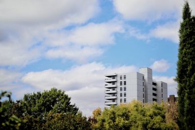 Low angle view of trees and buildings against sky