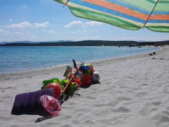 Man with umbrella on beach against sky