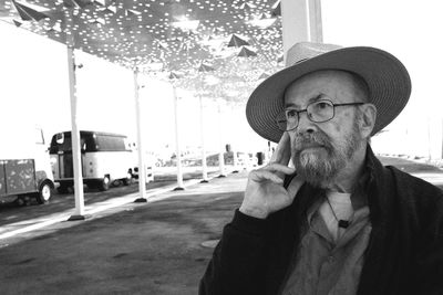 Side view of man wearing hat standing in city