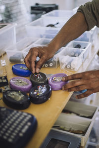 Hands of male fashion designer picking up straight pins at workshop