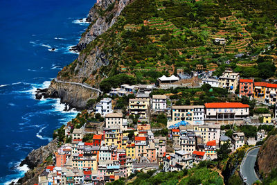 High angle view of riomaggiore village on mountain by sea