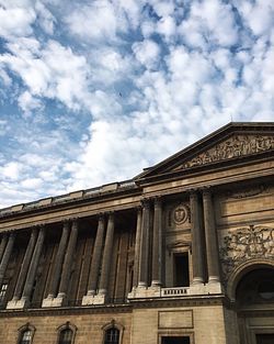 Low angle view of building against cloudy sky