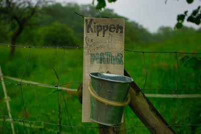 Text on fence against plants