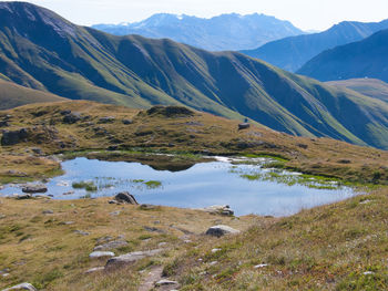 Scenic view of lake by mountains against sky