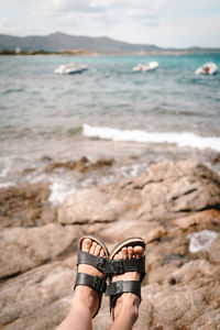 Low section of person on rock at beach