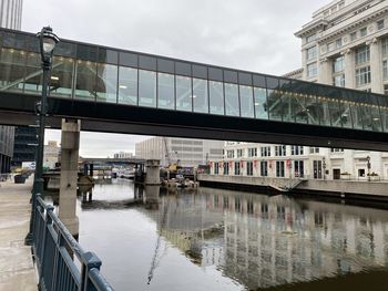 Bridge over canal in city against sky