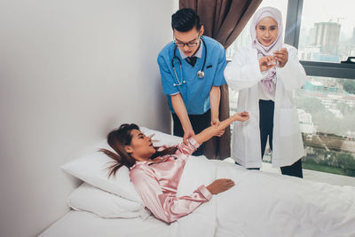 Full length of woman sitting on bed