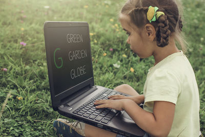 Young woman using laptop at park