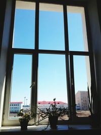 Buildings against clear sky seen through window