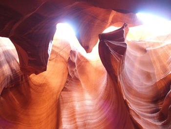 Low angle view of sunlight streaming through rocks