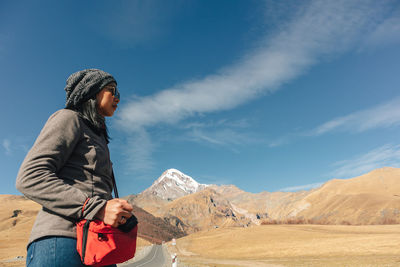 Woman standing on mountain against sky