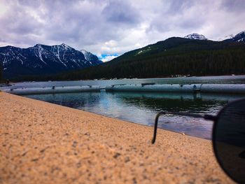 Scenic view of lake and mountains against cloudy sky