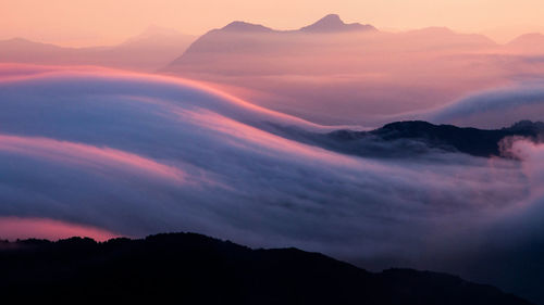 Scenic view of silhouette mountains against sky at sunset