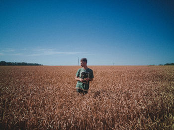 Man standing on field against clear sky