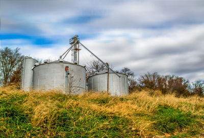 Traditional grain silo's on field against sky
