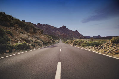 Surface level of empty road against mountain range