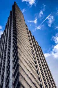 Low angle view of modern building against cloudy sky